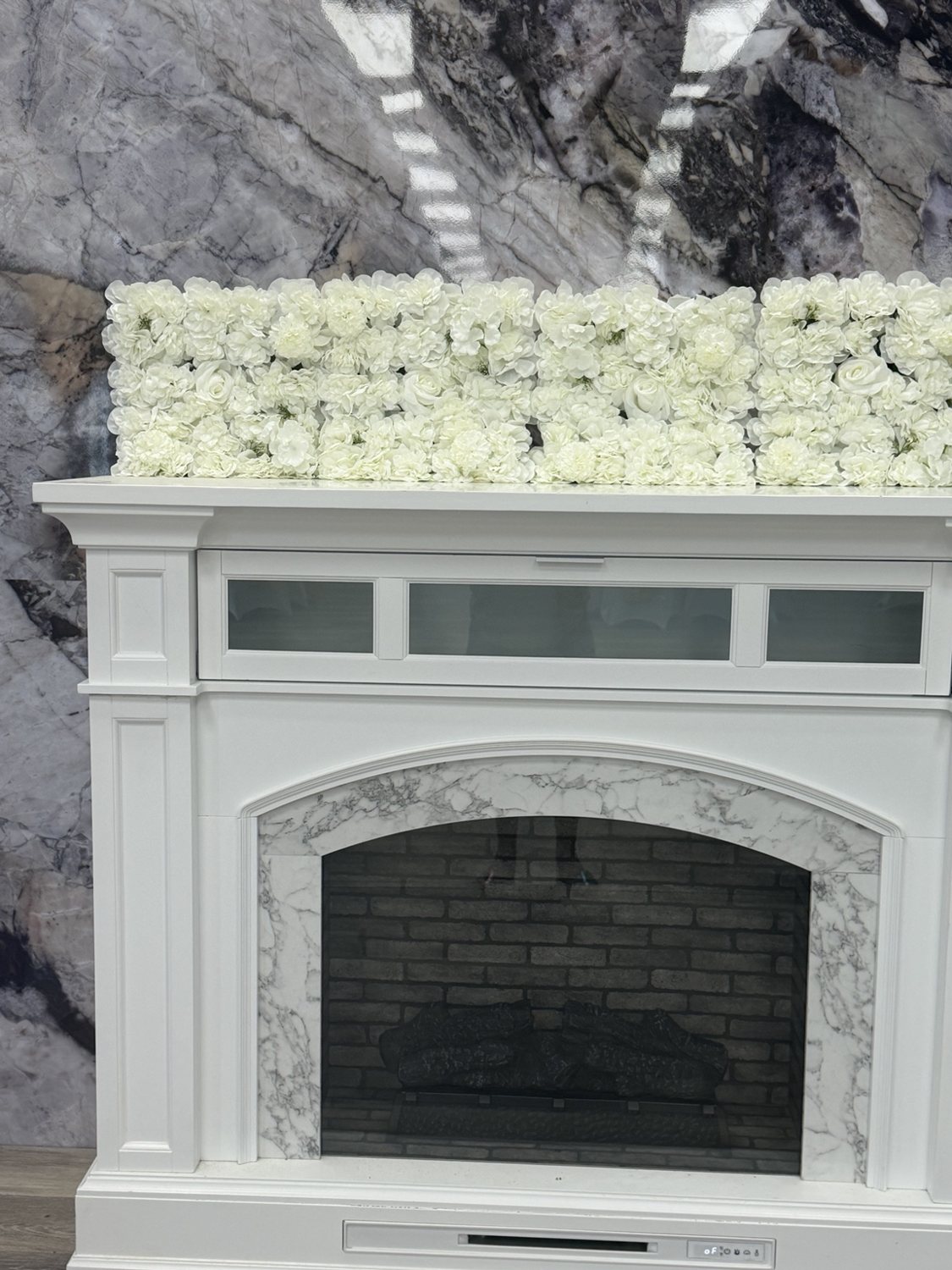 White floral arrangement above a white fireplace