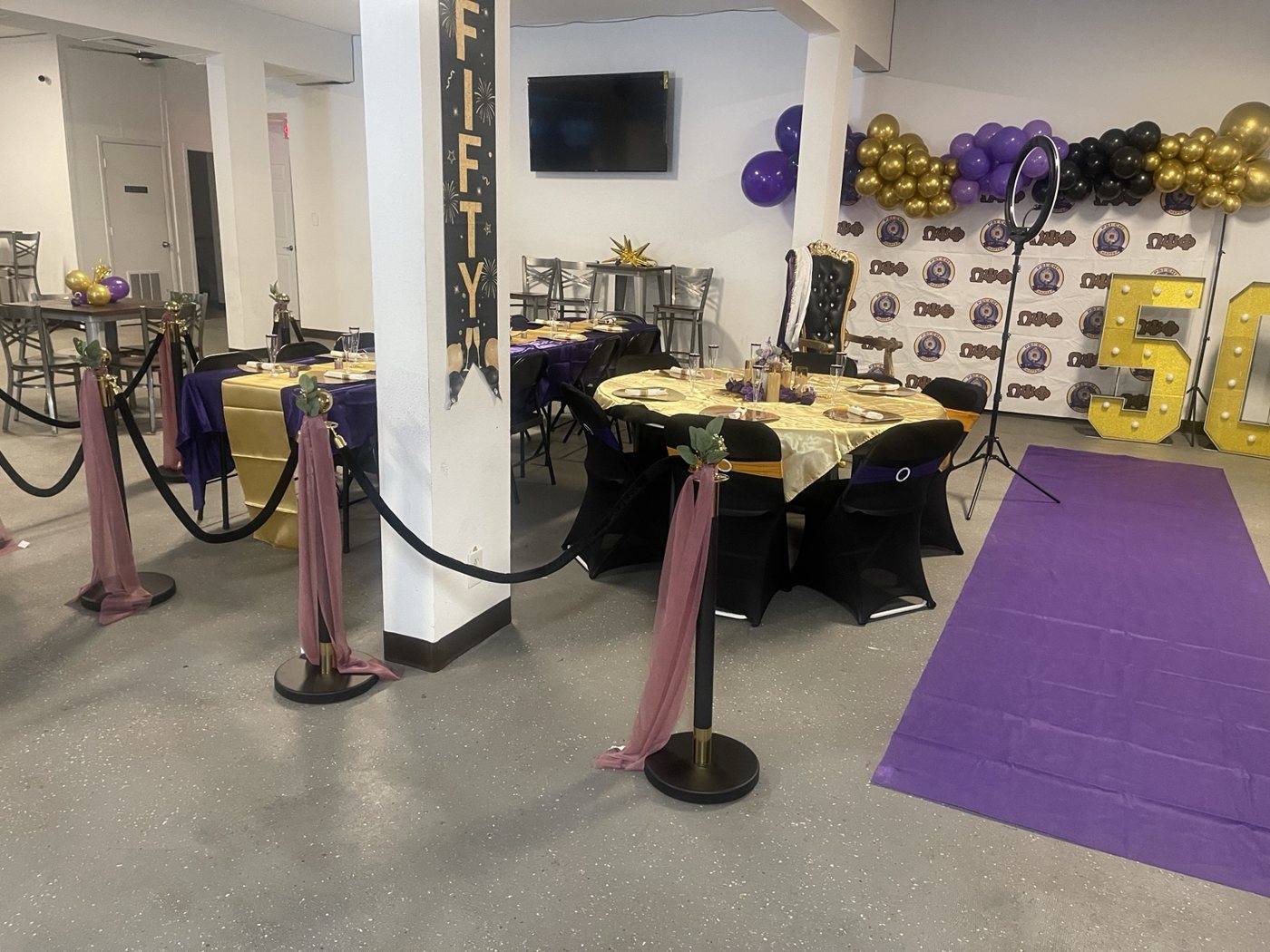 Gold number 50 display beside decorated celebration tables