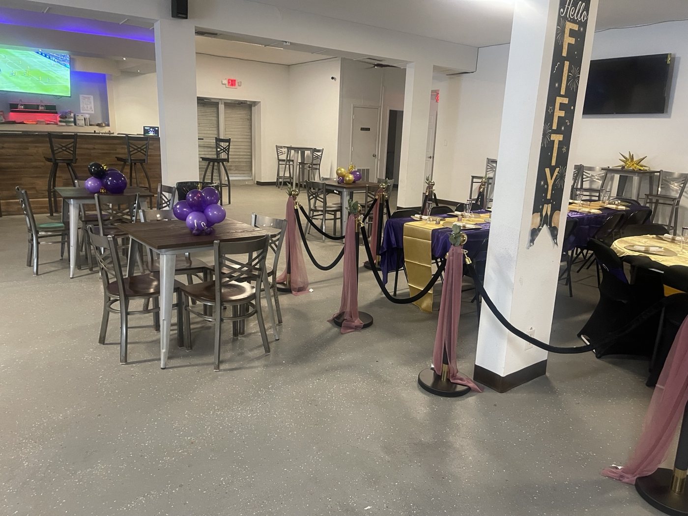 Event seating and tables decorated in purple, black, and gold
