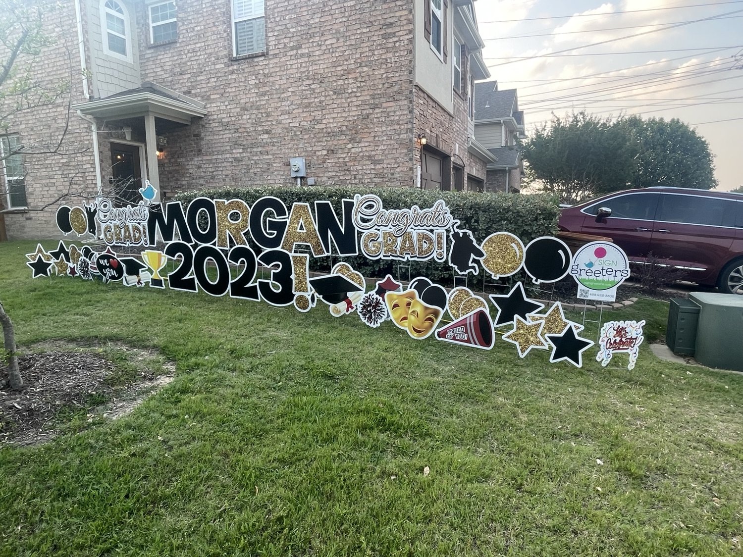 Gold, black, and white graduation yard display